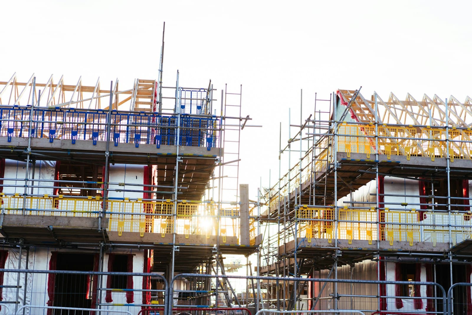 Rows of new houses under construction with wooden framing and scaffolding
